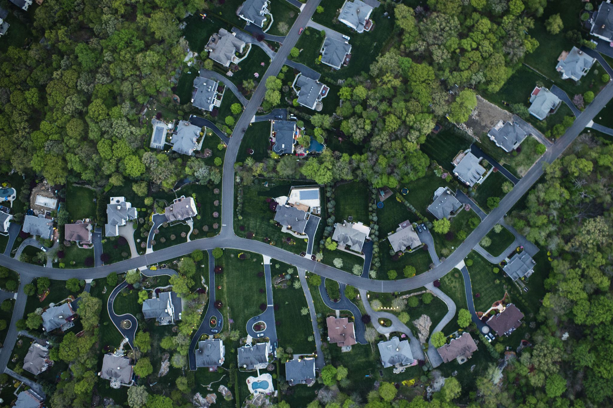 Aerial-view-of-suburb,-showing-houses,-lawns,-and-trees